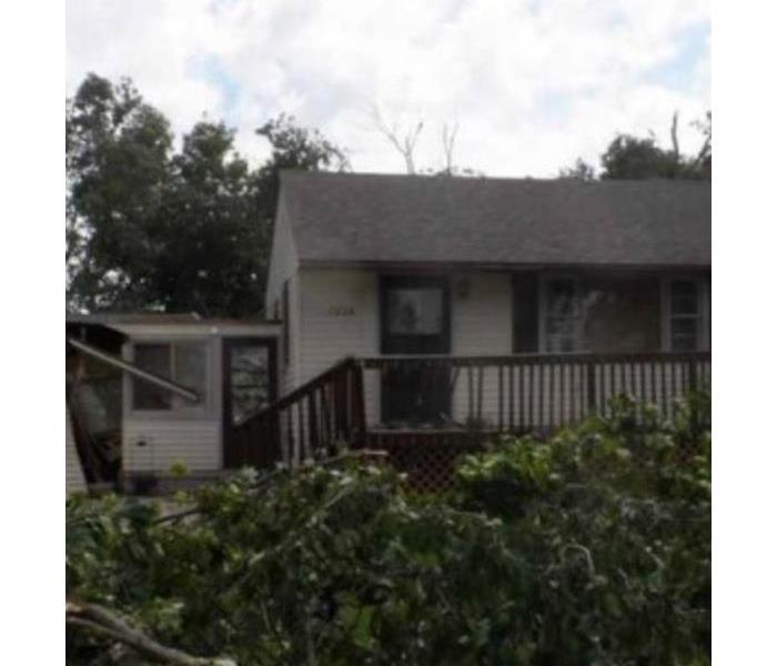 a picture of a house with a fallen tree in the front