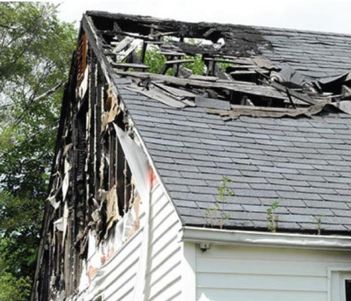 a picture of a house with the roof partially ripped off